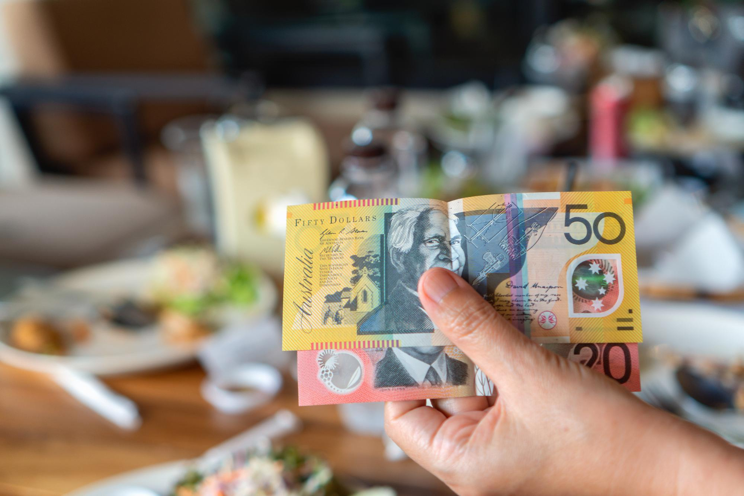 woman s hand holding australian notes make payment restaurant